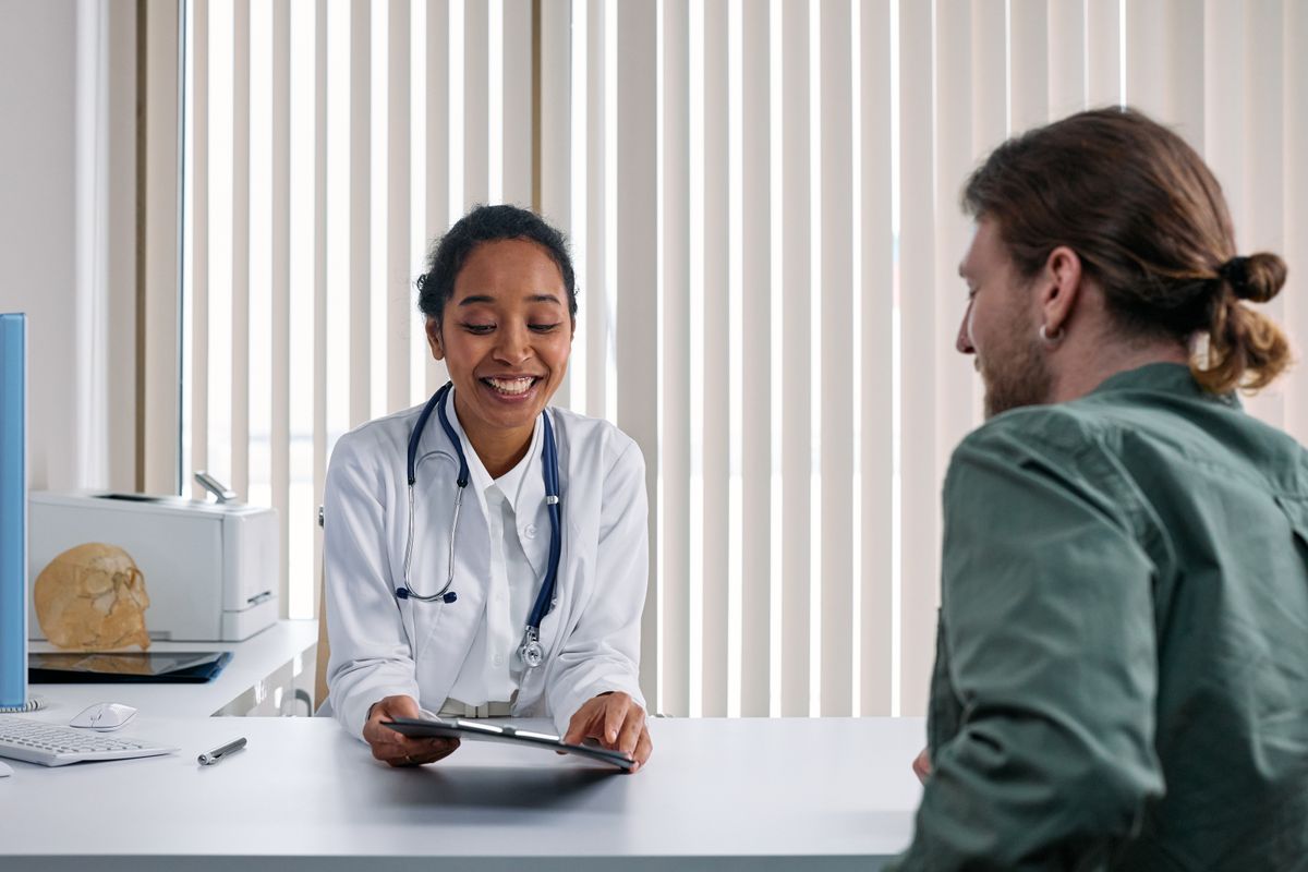 Médica conversando com um paciente durante a consulta