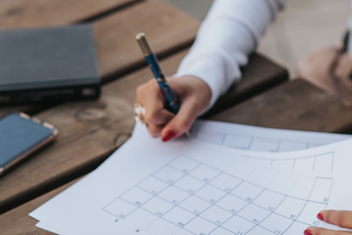 Pessoa marcando datas em um calendário