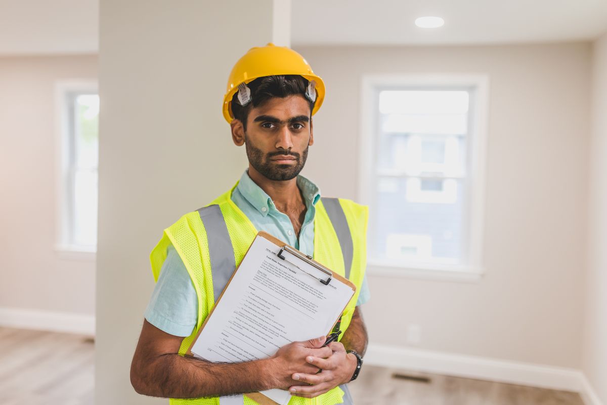 Técnico de segurança do trabalho com capacete segurando uma prancheta
