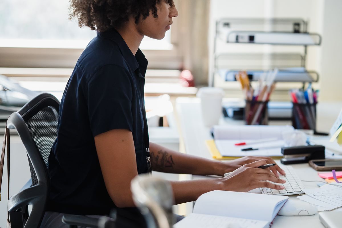 Profissional digitando em um posto de trabalho de escritório